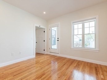 210 Adams Street, Unit 4 Waltham, MA 02453 - Photo 15 of 25 an empty room with wooden floor and windows