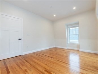 210 Adams Street, Unit 4 Waltham, MA 02453 - Photo 16 of 25 a view of empty room with wooden floor and fan