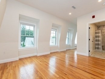 210 Adams Street, Unit 4 Waltham, MA 02453 - Photo 18 of 25 an empty room with wooden floor and windows