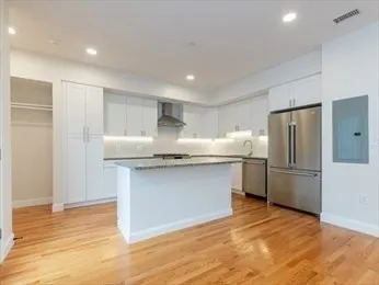 a kitchen with granite countertop a refrigerator and a sink