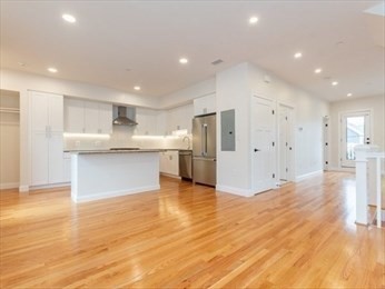 210 Adams Street, Unit 4 Waltham, MA 02453 - Photo 4 of 25 a large kitchen with stainless steel appliances kitchen island a large counter top and a floors