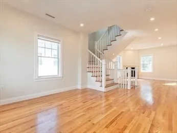 a view of empty room with wooden floor
