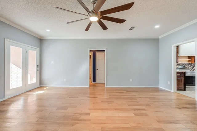 a view of an empty room with window and a kitchen