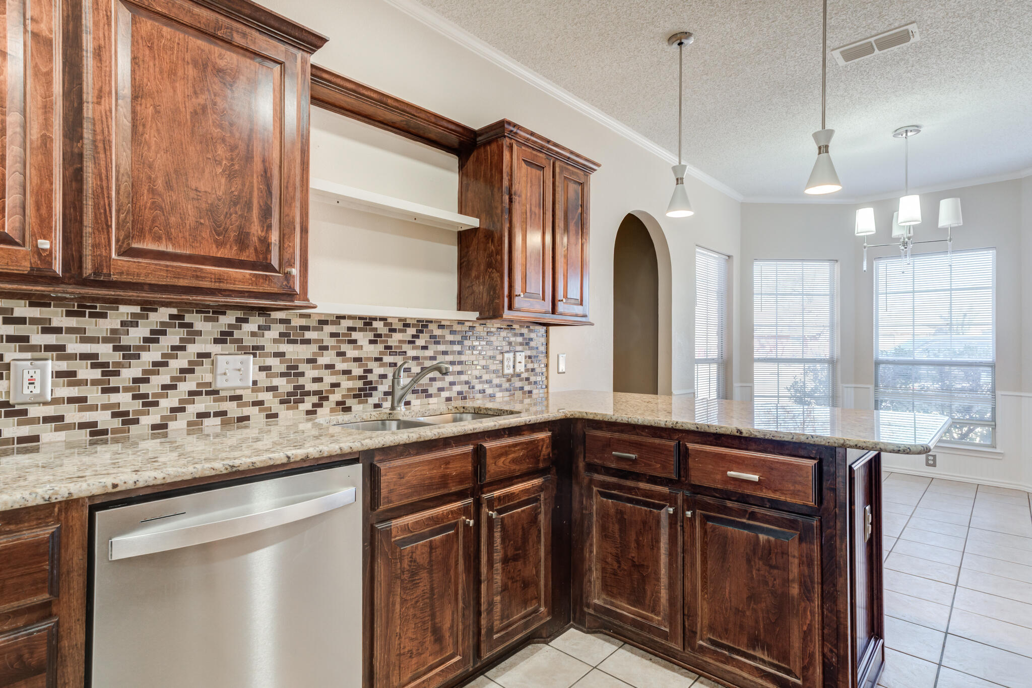 5917 88th Place Lubbock, TX 79424 - Photo 16 of 45 a kitchen with granite countertop a sink a counter space and stainless steel appliances