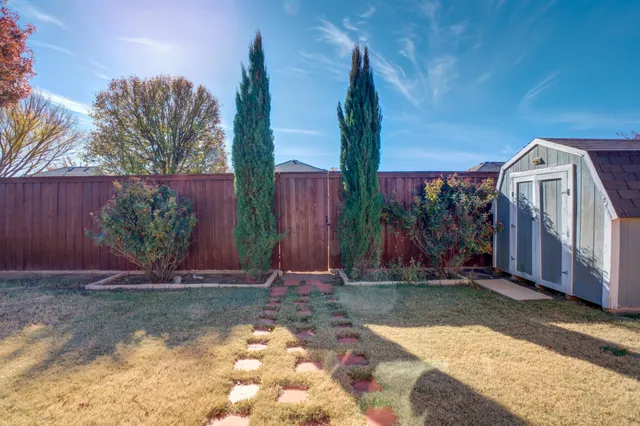 a view of a house with backyard and trees