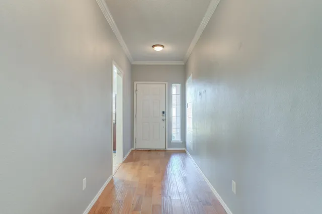 a view of a hallway with wooden floor