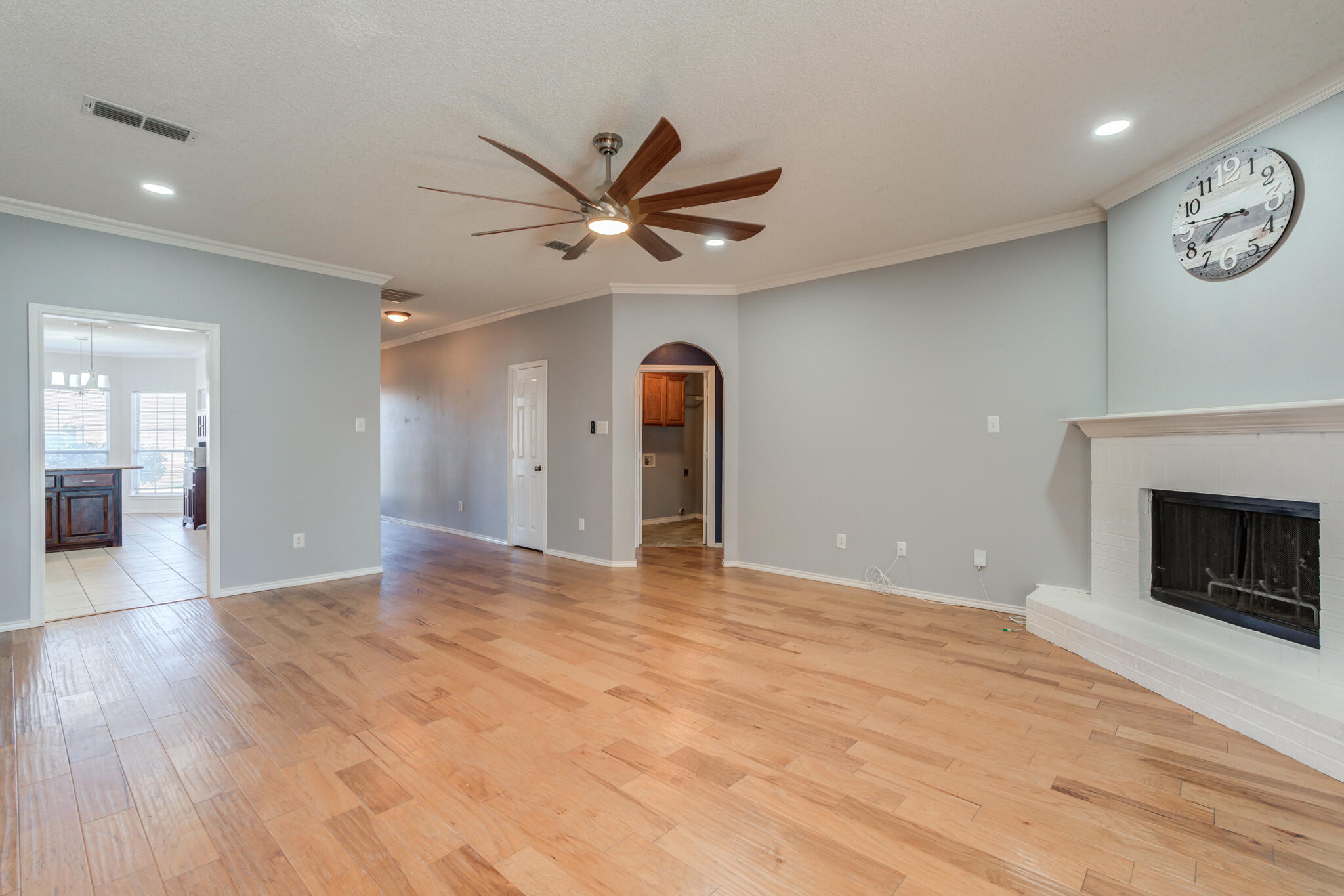 5917 88th Place Lubbock, TX 79424 - Photo 10 of 45 a view of a livingroom with a fireplace a ceiling fan and wooden floor