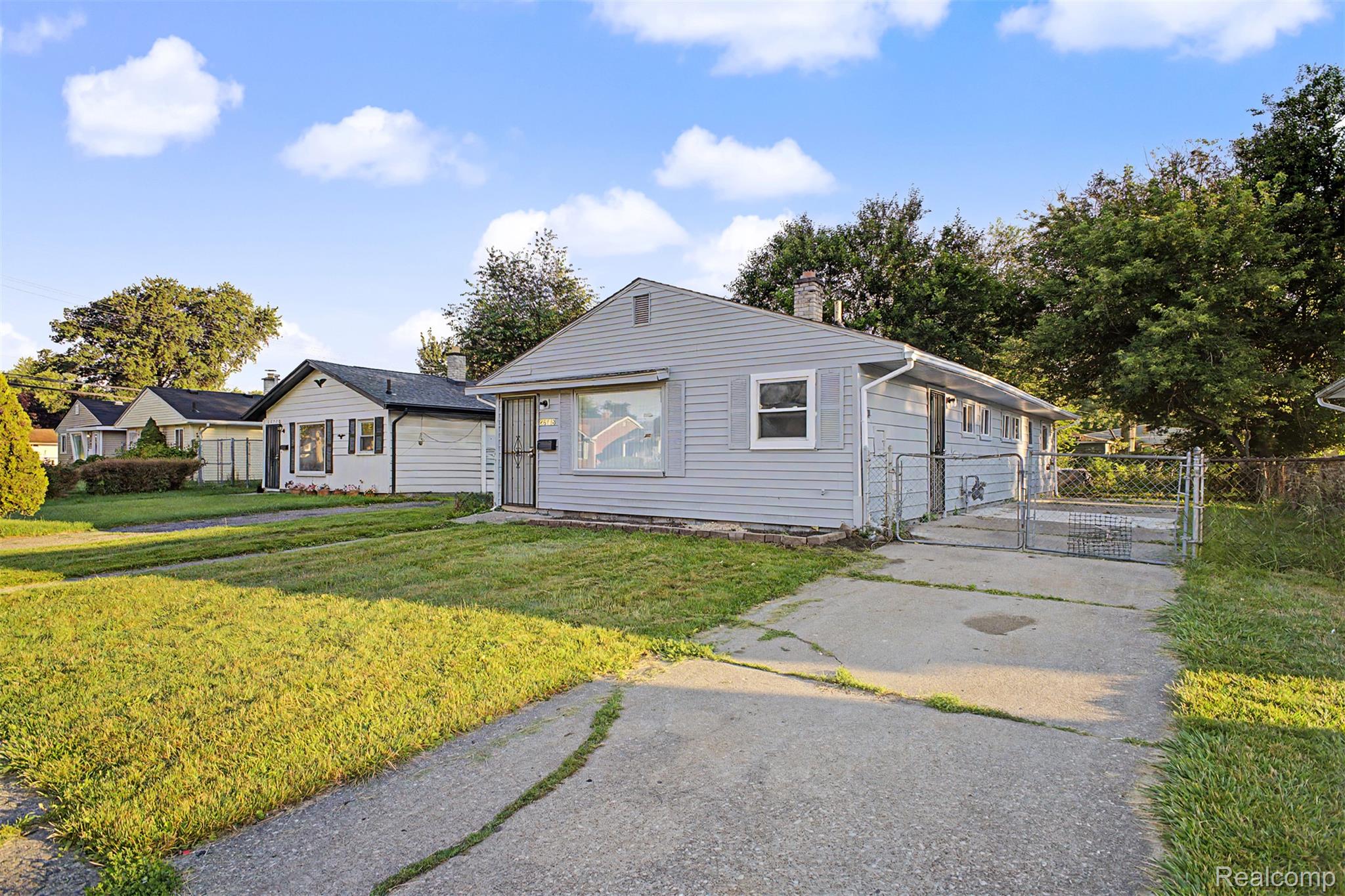 26718 Penn Street Inkster, MI 48141 - Photo 3 of 27 Light blue siding exterior with a pitched roof and a concrete driveway