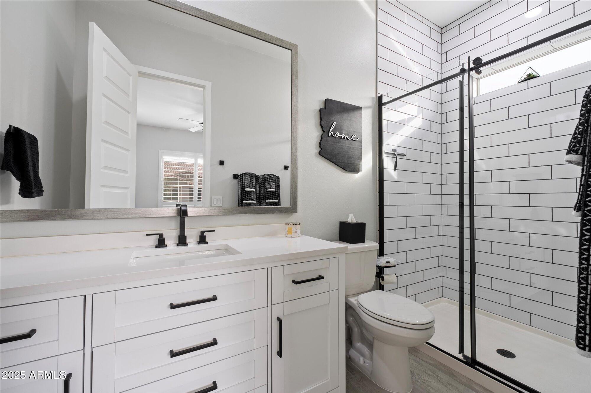 20954 East Camacho Road Queen Creek, AZ 85142 - Photo 18 of 35 a bathroom with a toilet sink vanity and mirror