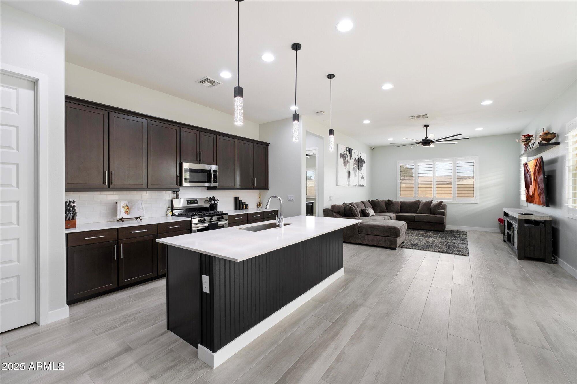 20954 East Camacho Road Queen Creek, AZ 85142 - Photo 5 of 35 a kitchen with wooden cabinets and stainless steel appliances