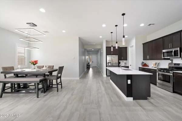 a view of a dining room and livingroom with furniture wooden floor a chandelier