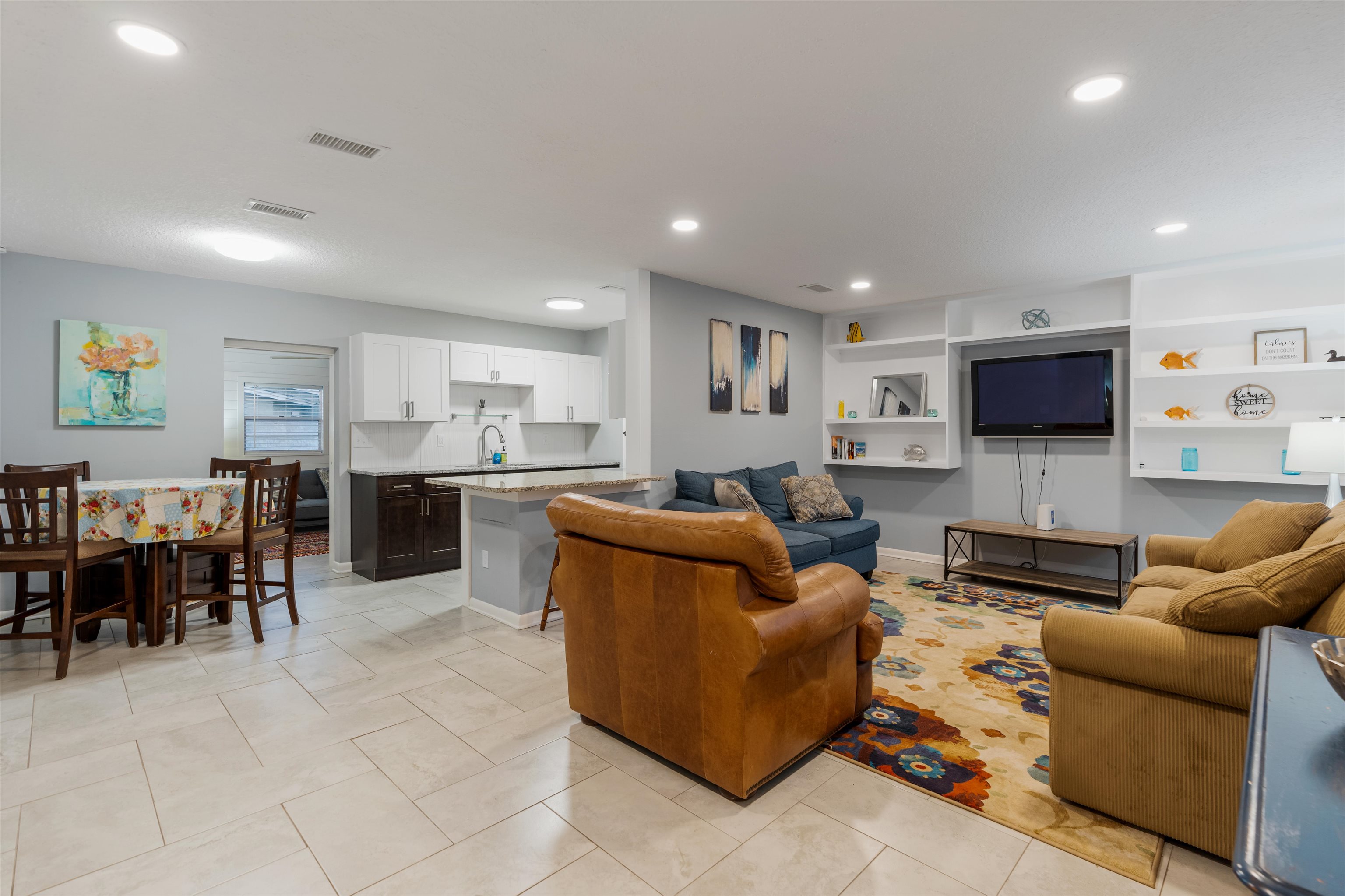 311 Deltona Boulevard St. Augustine, FL 32086 - Photo 3 of 16 a living room with furniture a kitchen view and a flat screen tv