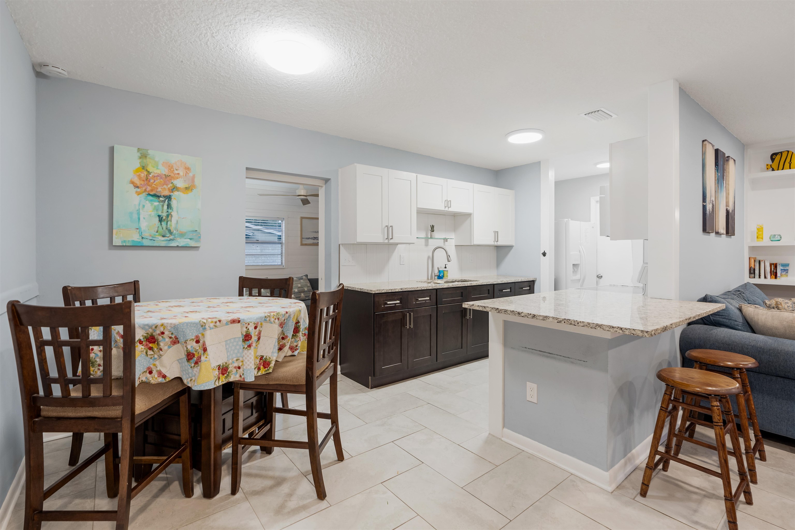 311 Deltona Boulevard St. Augustine, FL 32086 - Photo 5 of 16 a kitchen with a dining table chairs and white cabinets