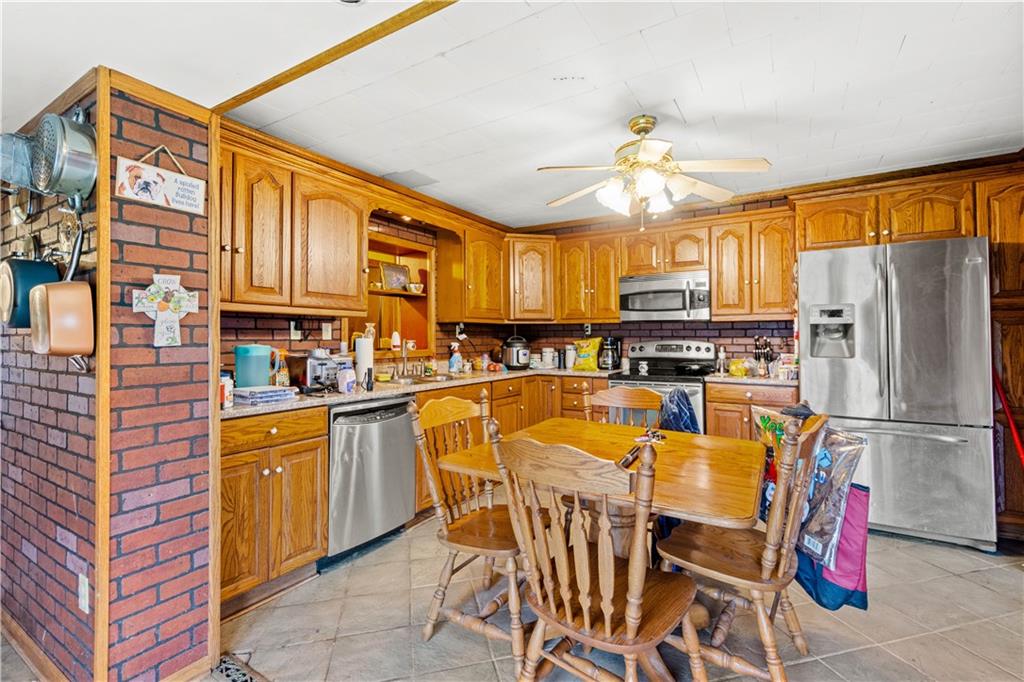 571 Highland Ridge Road Marianna, PA 15345 - Photo 6 of 25 a kitchen with stainless steel appliances granite countertop a refrigerator a stove top oven a sink dishwasher and wooden cabinets