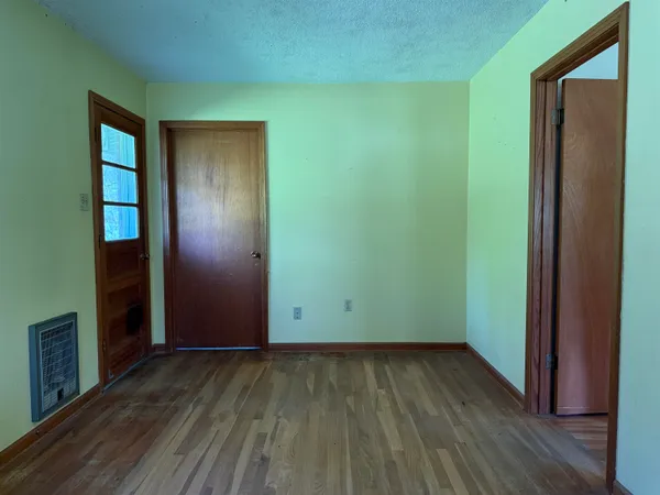 an empty room with wooden floor and closet