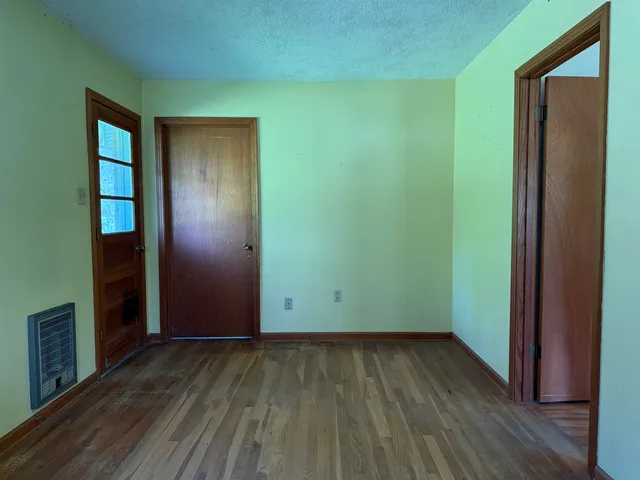 an empty room with wooden floor and closet
