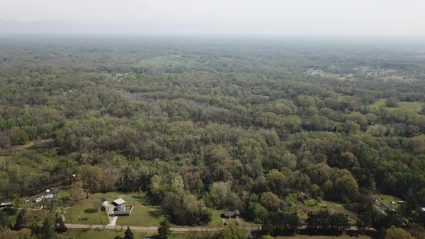 an aerial view of house with yard and mountain view in back