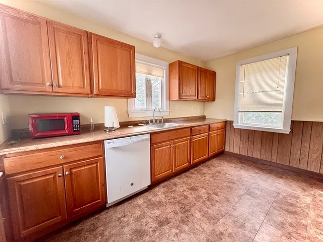a kitchen with a sink window and cabinets