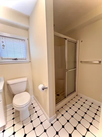 a bathroom with a toilet and a shower