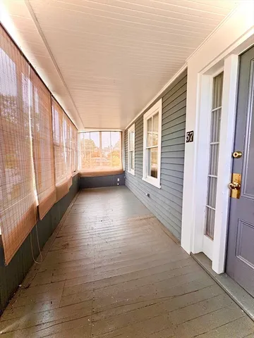 a view of a porch with wooden floor and windows