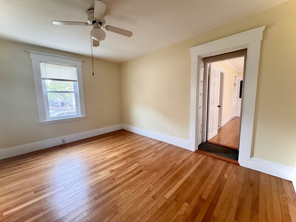 57 Adams Avenue Newton, MA 02465 - Photo 7 of 38 an empty room with wooden floor chandelier fan and windows
