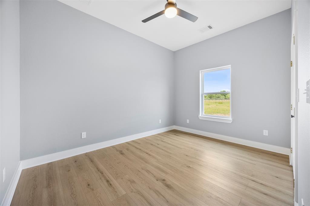 121 Brazier Road Ennis, TX 75119 - Photo 20 of 31 an empty room with a window and wooden floor