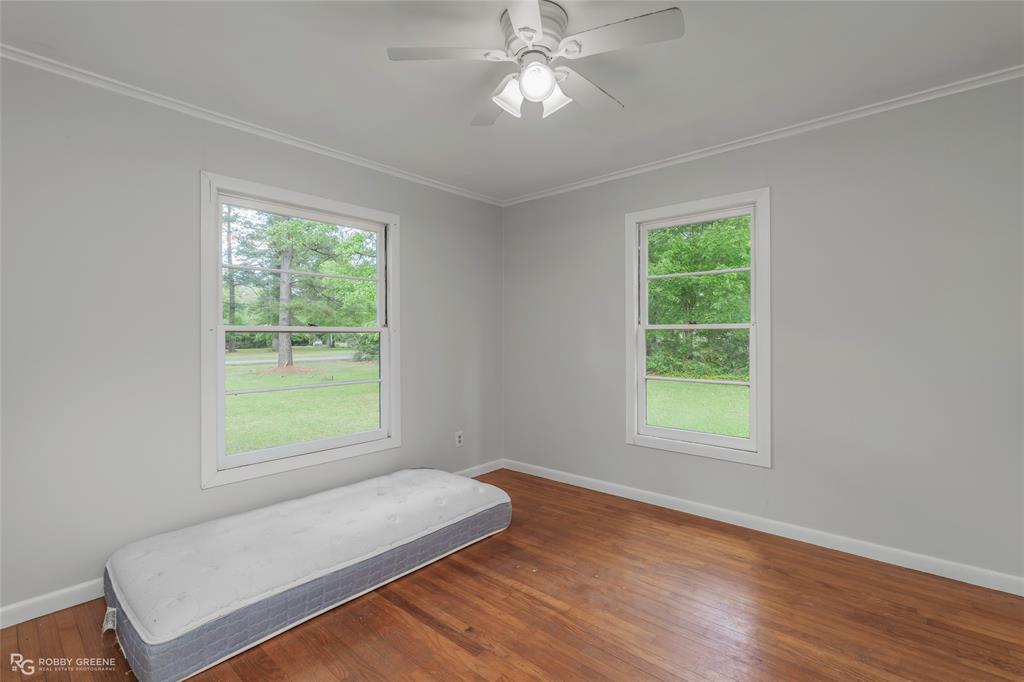 5725 Harper Road Keithville, LA 71047 - Photo 9 of 35 an empty room with wooden floor and windows