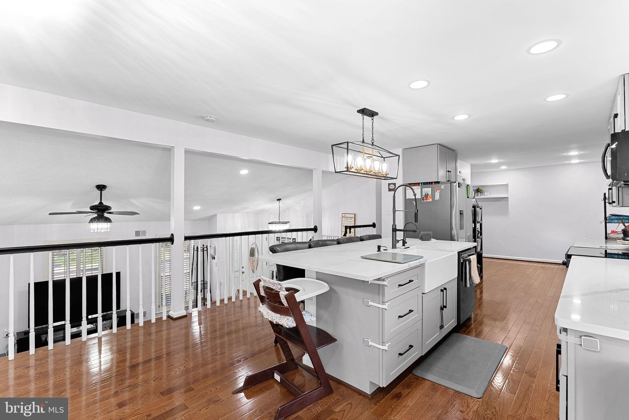 6208 Ormandy Drive Burke, VA 22015 - Photo 14 of 57 a large white kitchen with a large island oven a sink and chairs