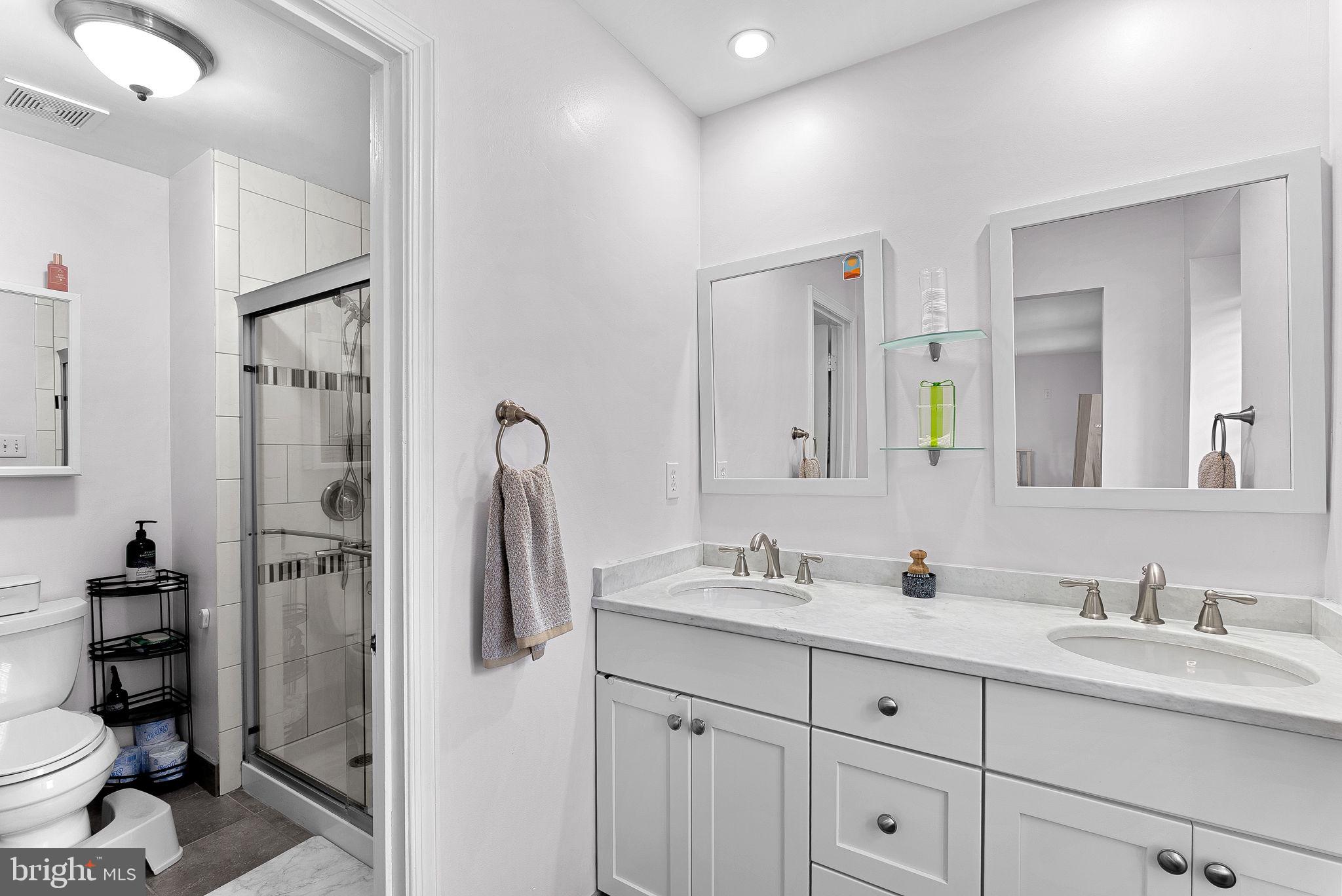 6208 Ormandy Drive Burke, VA 22015 - Photo 27 of 57 a bathroom with a double vanity sink toilet and shower