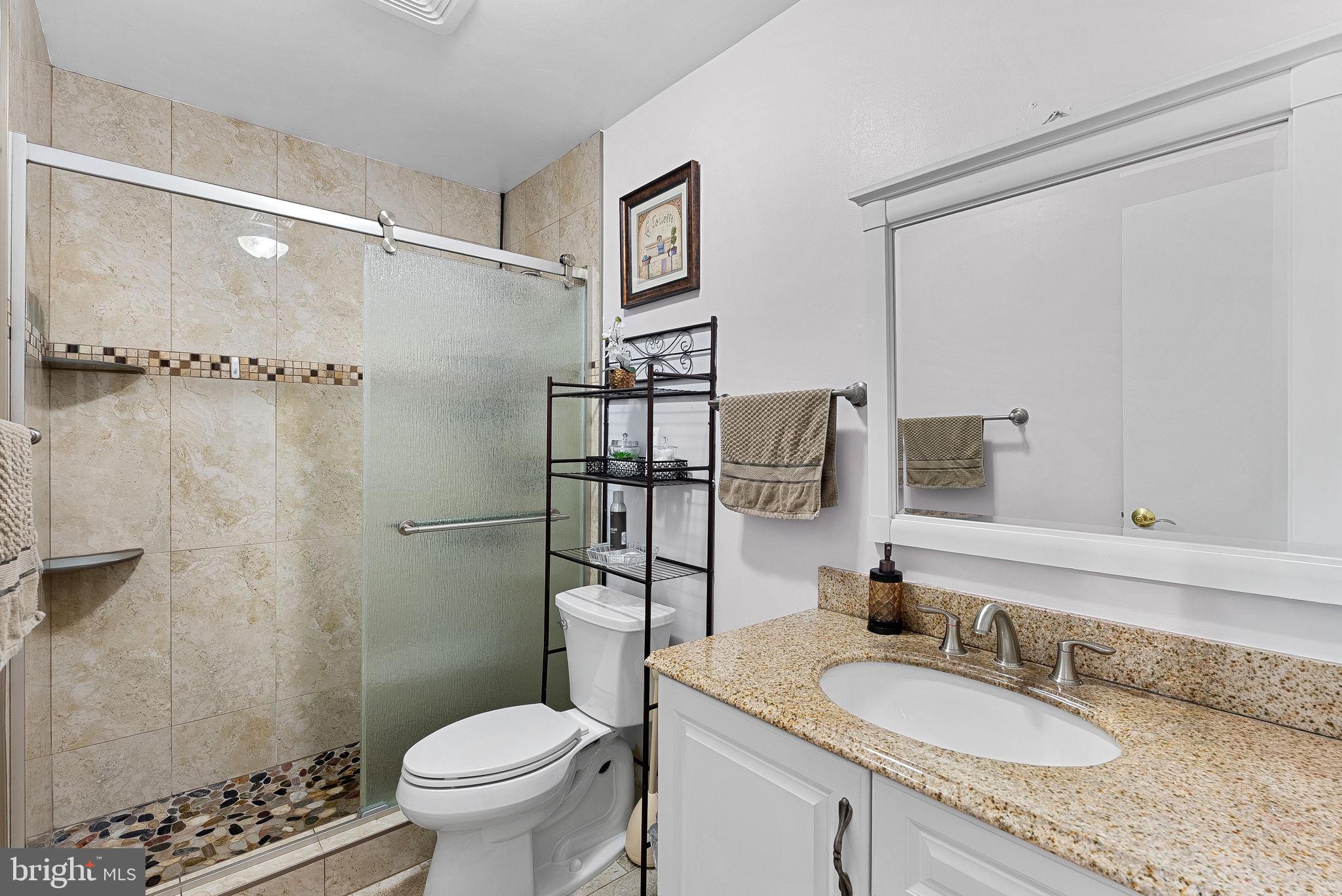 6208 Ormandy Drive Burke, VA 22015 - Photo 38 of 57 a bathroom with a granite countertop sink toilet and shower
