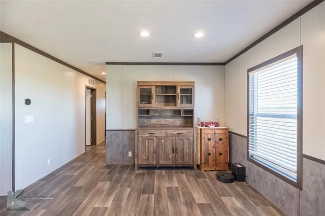 a view of a livingroom with wooden floor and furniture