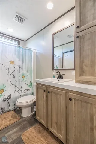 a bathroom with a granite countertop sink mirror vanity and toilet