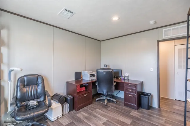 a view of workspace with wooden floor lounge chair windows cabinet