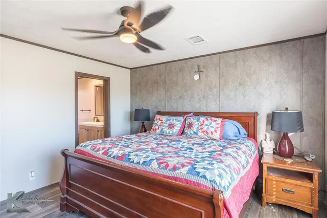 a bedroom with a bed and a lamp on the dresser