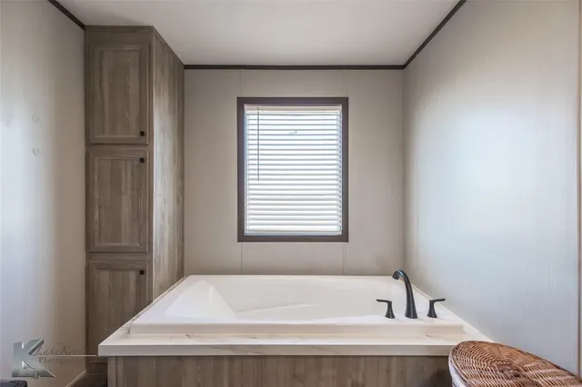a bath tub sitting in a bathroom next to a window