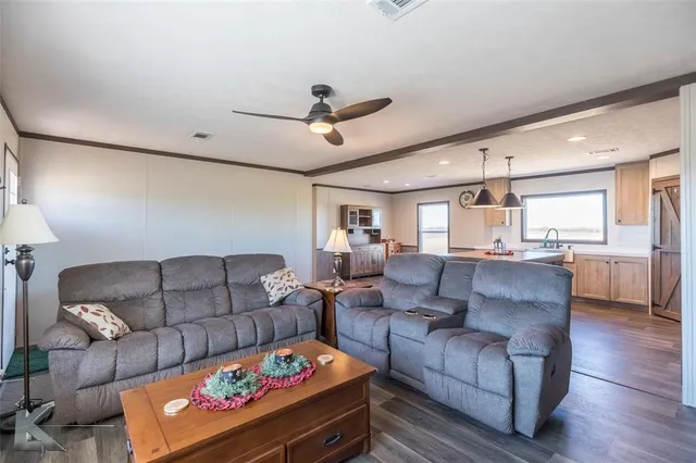 a living room with furniture and a dining table with kitchen view