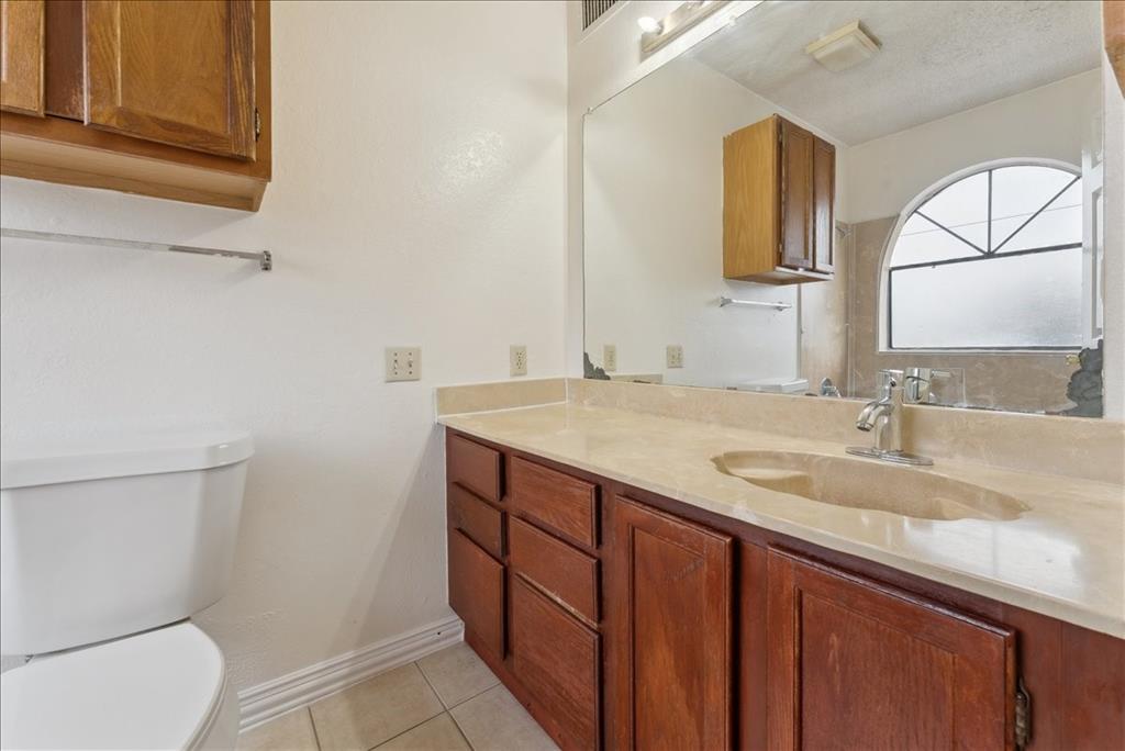 6108 Abrams Road, Unit 330 Dallas, TX 75231 - Photo 13 of 18 a bathroom with a granite countertop toilet sink and mirror