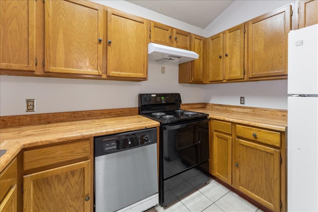 6108 Abrams Road, Unit 330 Dallas, TX 75231 - Photo 6 of 18 a kitchen with stainless steel appliances granite countertop white cabinets stove a sink and dishwasher