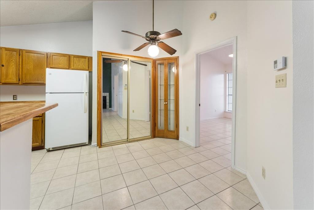 6108 Abrams Road, Unit 330 Dallas, TX 75231 - Photo 9 of 18 a view of a refrigerator in kitchen and an empty room in wooden floor