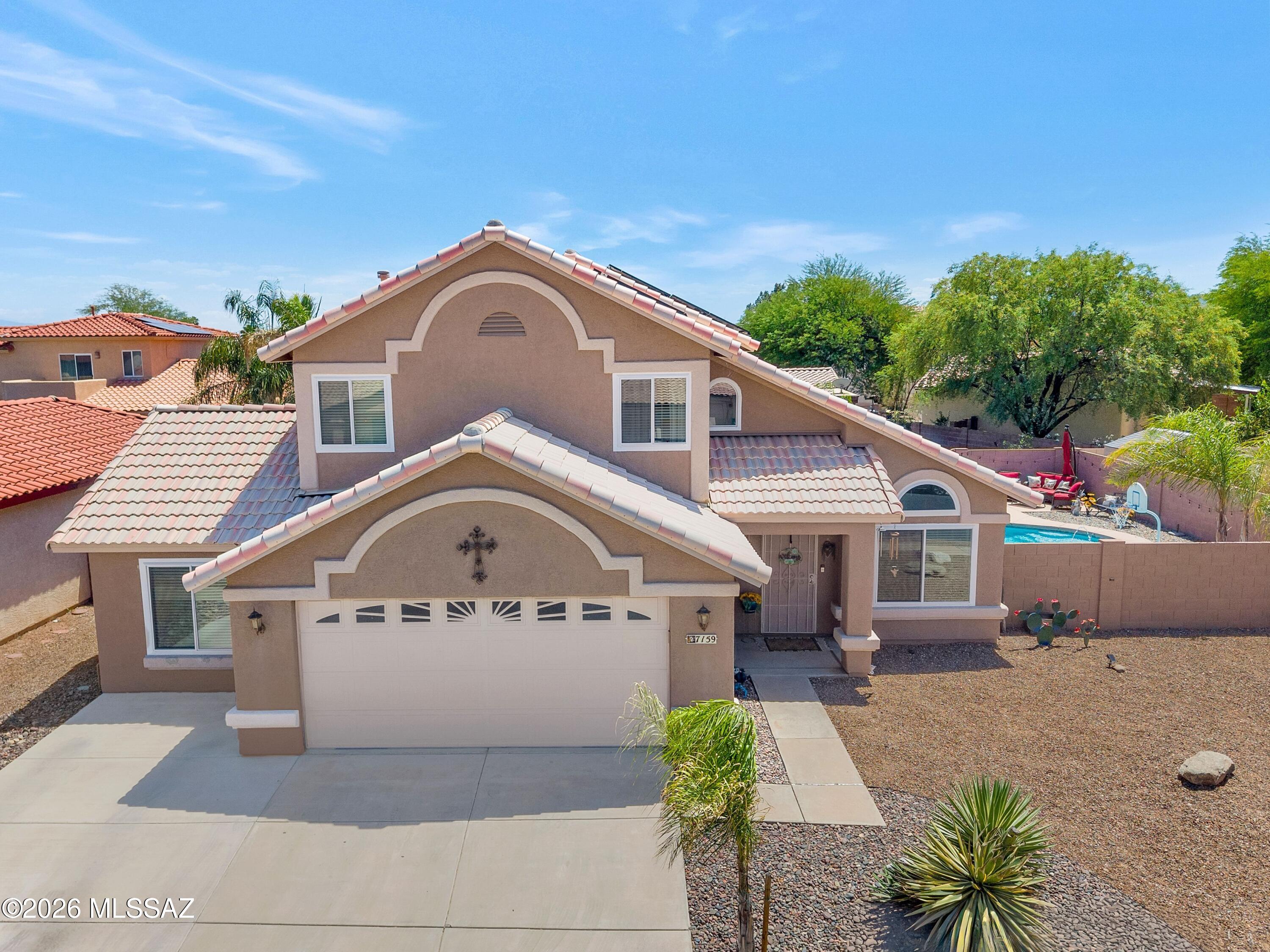 7159 West Maple Ridge Drive Tucson, AZ 85743 - Photo 1 of 42 a front view of a house with a yard and garage