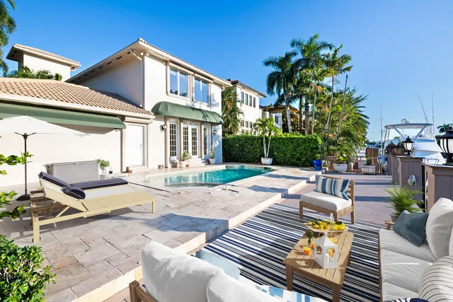 a view of a patio with couches table and chairs and potted plants