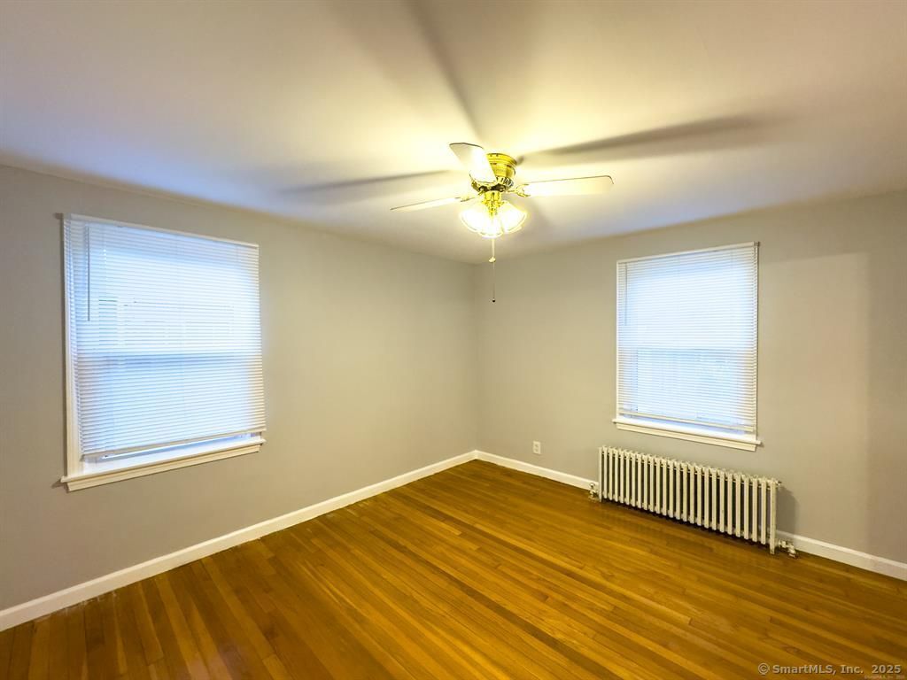 111 Irving Left Side Street Naugatuck, CT 06770 - Photo 4 of 11 an empty room with wooden floor fan and windows