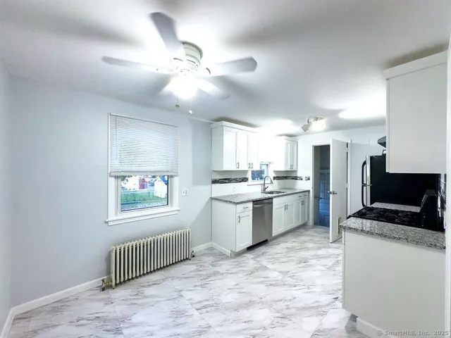 a kitchen with granite countertop a sink stainless steel appliances and cabinets
