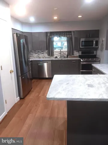 a large kitchen with stainless steel appliances a large counter top