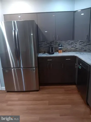 a kitchen with stainless steel appliances granite countertop a refrigerator a sink and a stove