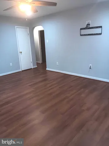 an empty room with wooden floor and mirror