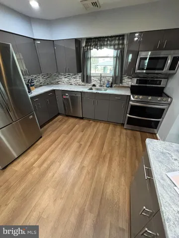 a kitchen with kitchen island granite countertop a stove and a sink