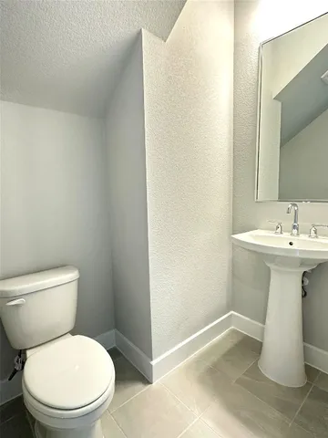 a bathroom with a sink toilet and a mirror