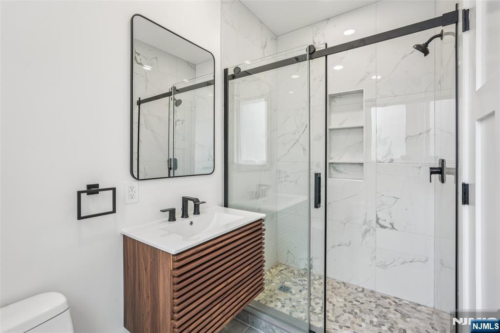 492 Oaktree Road Oradell, NJ 07649 - Photo 16 of 43 a bathroom with a sink and a mirror