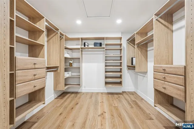 a view of walk in closet with clothes and shoes